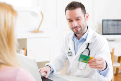 doctor taking health insurance card to patient