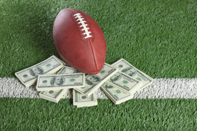 NFL football on field with a pile of money